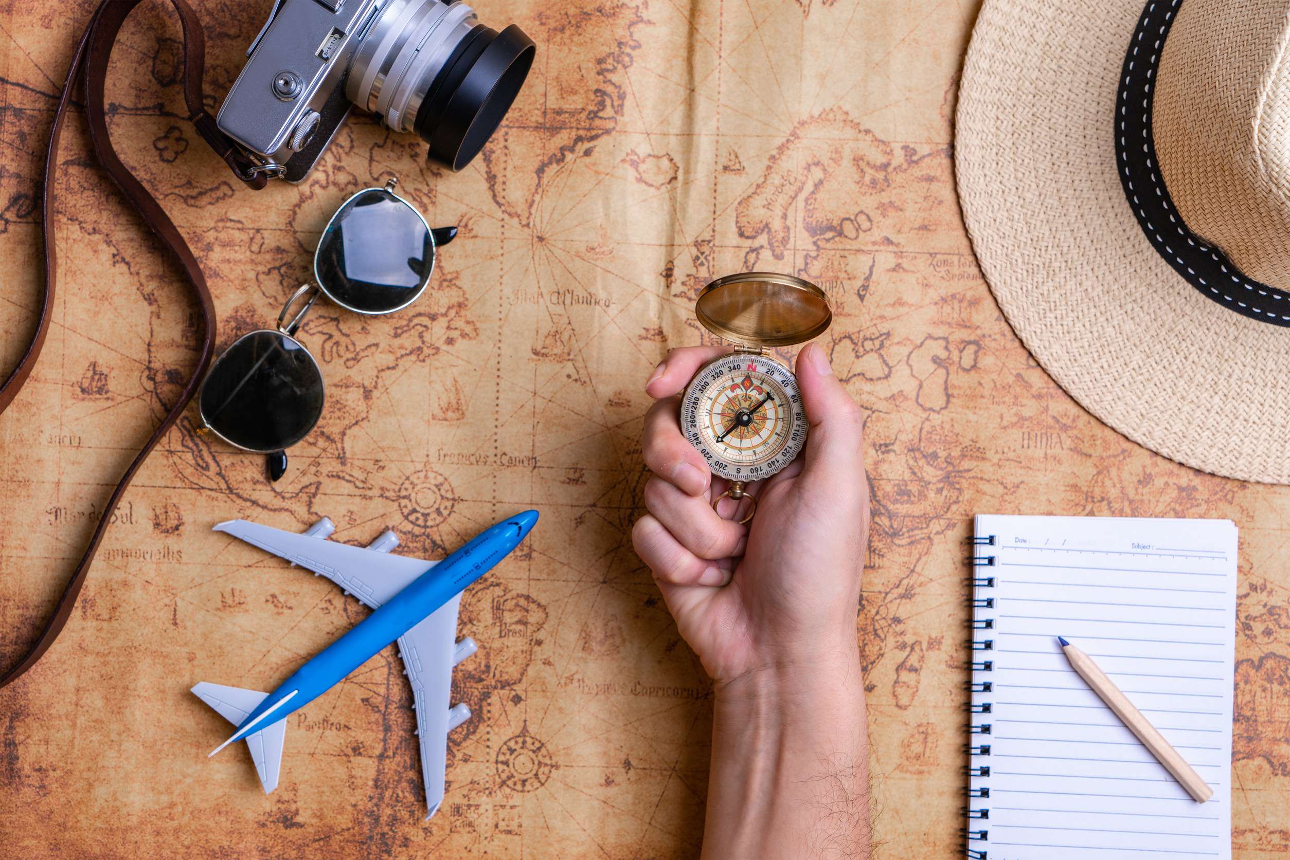 Hand Holding Compass With Accessories For Travel Concept